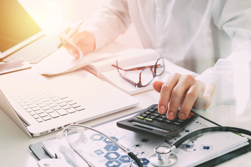 Photo of bills, calculator and glasses.