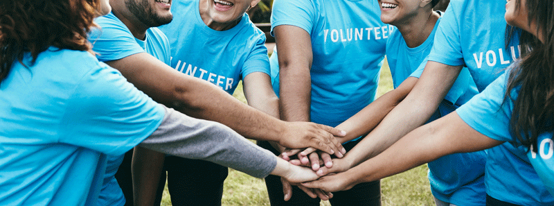 Volunteers putting their hands together.
